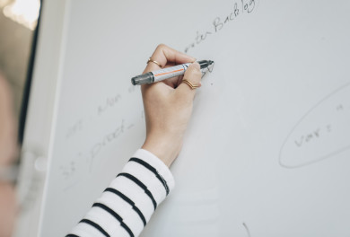 une main écrit sur le tableau